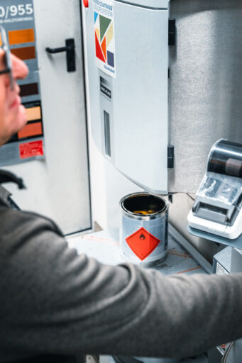 Mitarbeiter an der Farbmischmaschine